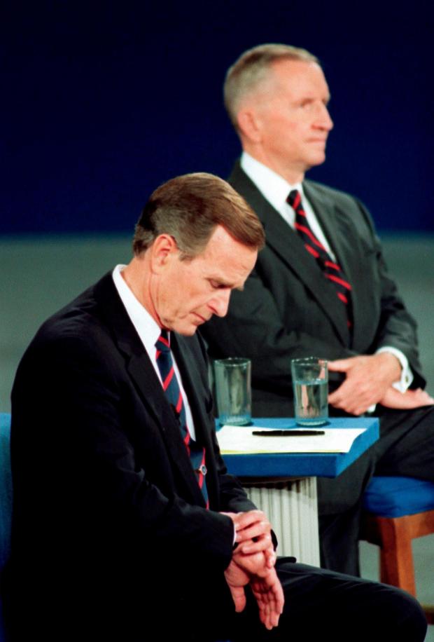 President George H.W. Bush looks at his watch during the 1992 presidential campaign debate with other candidates.