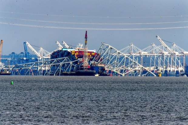 Apr 5, 2024: A view from Riviera Beach of the Francis Scott Key Bridge wreckage with removal underway after the Singapore-flagged container ship Dali struck one of the supports last week. (Karl Merton Ferron/Staff)