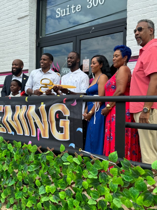 Owners Travis and Faith Reid opened Corkscrews & Brews in downtown Newport News. A grand opening was held in June with Mayor Phillip Jones holding the scissors on the left. (Courtesy photo)