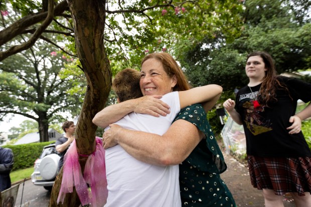 Sarah Pitts, left, and Lisa Suhay embrace after an energy healing ritual at the Fairy Tree in Norfolk, Virginia, on Aug. 8, 2024. (Billy Schuerman / The Virginian-Pilot)