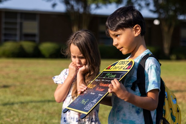 Amelia stands next to her brother Maric while their mother snaps a quick photo before the first day of school at Green Run Elementary in Virginia Beach on Monday, Aug. 26, 2024. (Kendall Warner / The Virginian-Pilot)