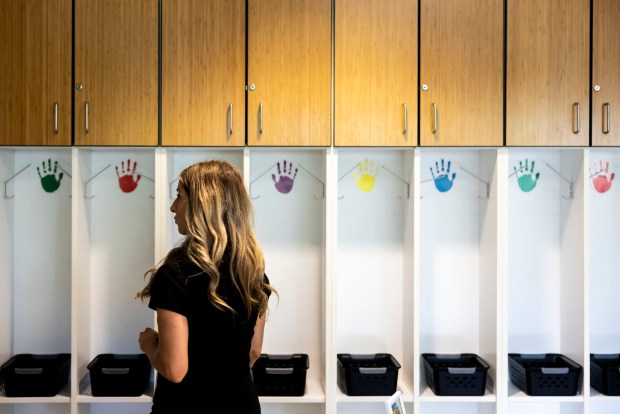 First-grade teacher Noelle Bonney hangs up different colored handprints, that will soon have her student's names on them, in the cubbies in her classroom at Simonsdale Elementary in Portsmouth on Friday, Aug. 18, 2024. (Kendall Warner / The Virginian-Pilot)