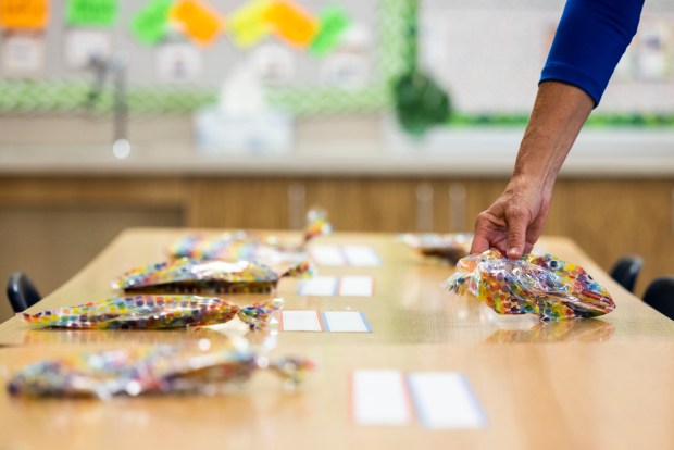 Kindergarten teacher Lois Ballman sets out welcome goodie bags for her students at Yates Elementary School in Newport News on Wednesday, Aug. 21, 2024. (Kendall Warner / The Virginian-Pilot)