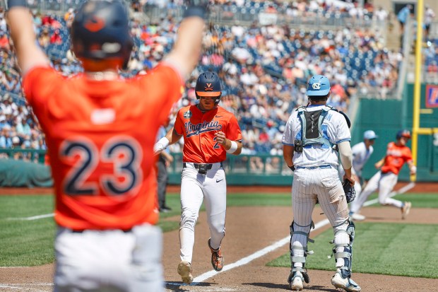 Virginia second baseman Henry Godbout scores a run on Griff O'Ferrall's sacrifice fly in the sixth inning of a College World Series game against North Carolina on Friday. (Courtesy of UVA)