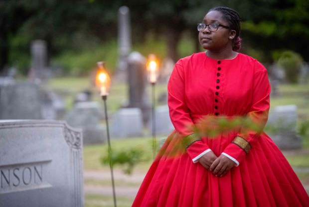 Antanae Shelton, a junior at the Mississippi School for Mathematics and Science, portrays a free woman of color who explains how, because of the many restrictions in her life, she was not really free at all, in "Tales From the Crypt," in Friendship Cemetery in Columbus, Miss., on April 3, 2024. Each spring, Columbus, Miss., has opened its Civil War-era homes to visitors. Some say the event should reflect more the oppression behind the architecture, and how the city has changed since. (Kate Medley/The New York Times)