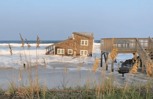 The Chicamacomico Fire and Rescue posted a video to its Facebook page Friday night, Aug. 16, 2024, showing a house that had fallen into the Atlantic Ocean. (Photo made from video posted to the Chicamacomico Fire and Rescue Facebook page)